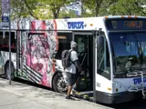 Passenger boarding TARTA bus wrapped with a vinyl mural in tribute to Rosa Parks